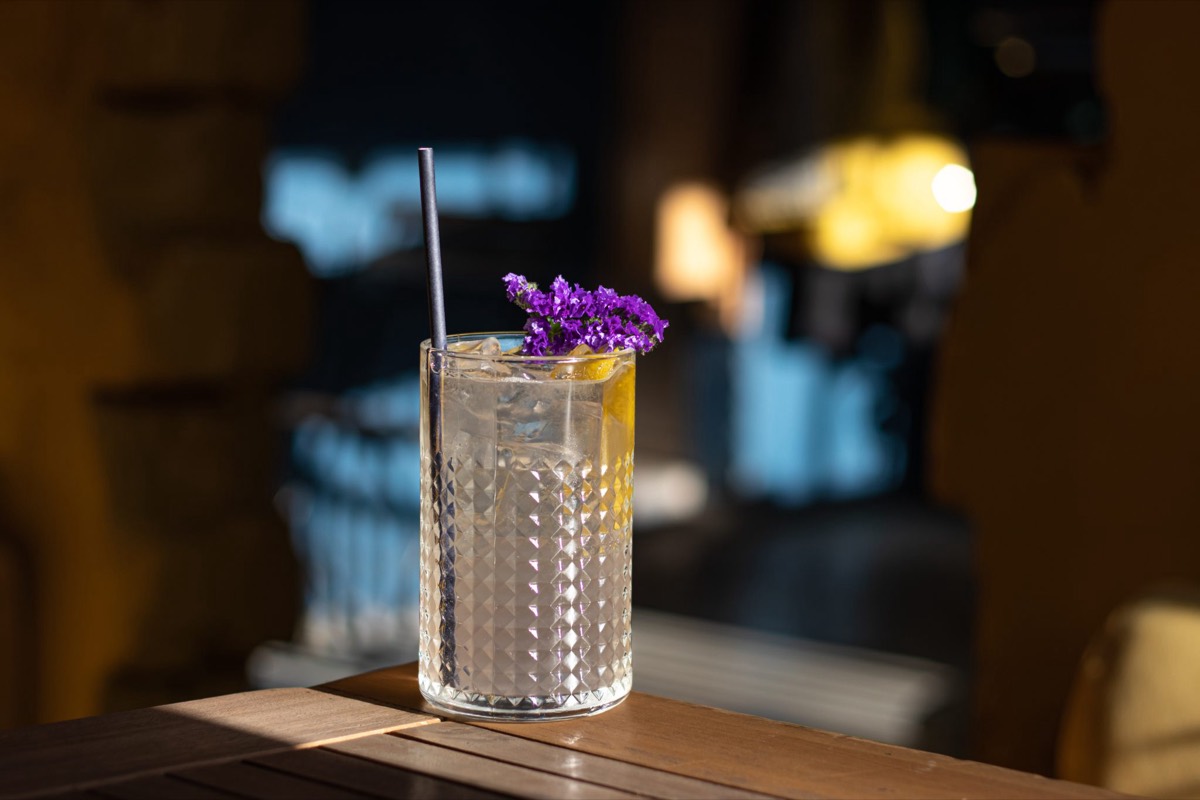 A cocktail on a bar table in low evening light