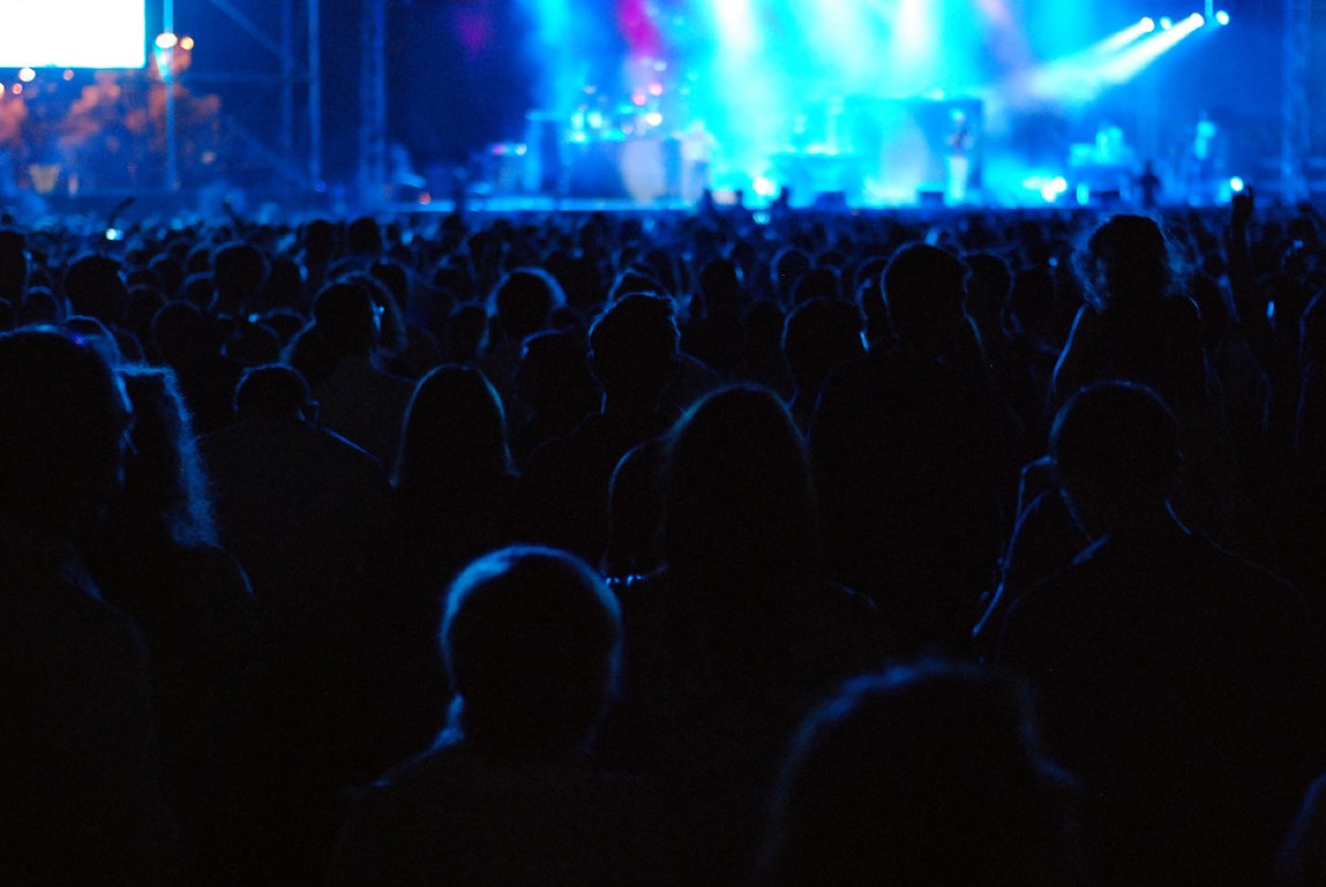 A concert crowd under blue stage lights